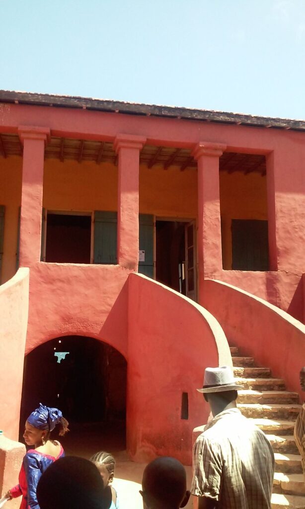 Facciata rossa della Casa degli Schiavi all'Isola di Gorée con il colonnato che appoggia su una grande scalinata