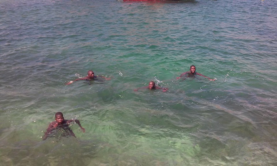 quattro ragazzi africani che nuotano in mare all'Isola di Gorée